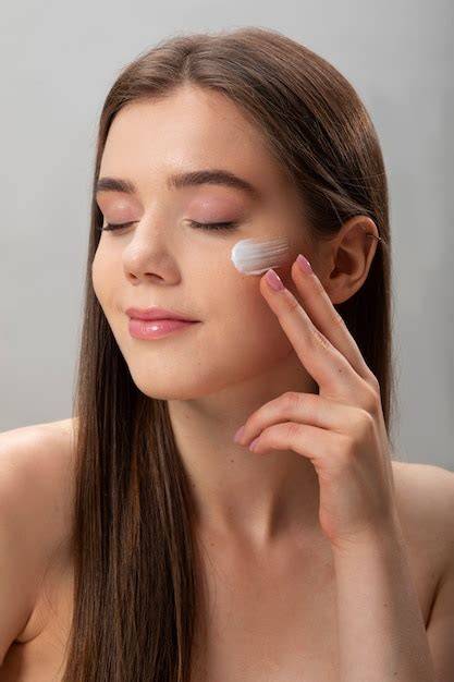 Foto de mujer embarazada aplicando crema facial, con productos Avène Hyaluron Activ B3 en primer plano