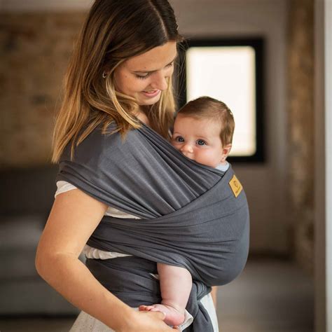 Bebé en fular elástico Ergobaby cerca de su madre