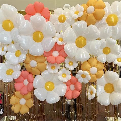 Globos de helio con forma de personajes de Winnie Pooh y un arco de globos en colores temáticos