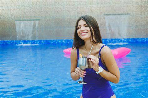Mujer embarazada feliz en traje de baño en la piscina