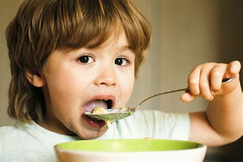 Niño comiendo con una cuchara de forma independiente