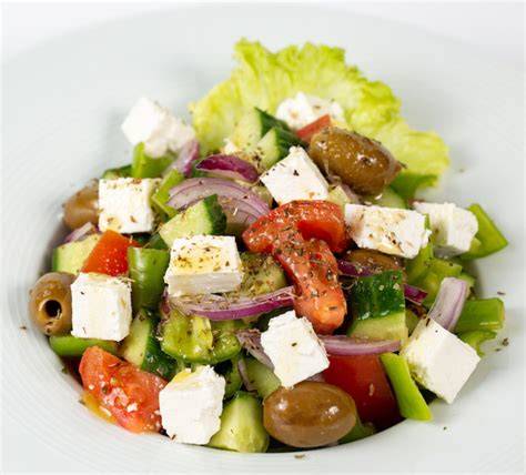 Plato de ensalada de patata con queso feta, aceitunas y verduras frescas