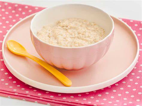 Bebé comiendo papilla de cereales de arroz, infografía sobre la introducción de sólidos