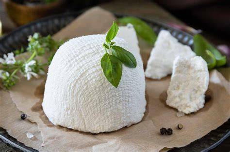 Queso Ricotta fresco en un recipiente con hierbas