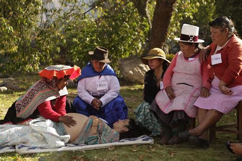 Fotografía de una partera tradicional interactuando con una familia en una comunidad rural