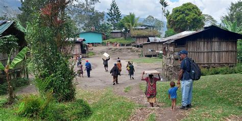 Fotografía de una comunidad rural donde varias mujeres interactúan con niños, simbolizando el cuidado colectivo.