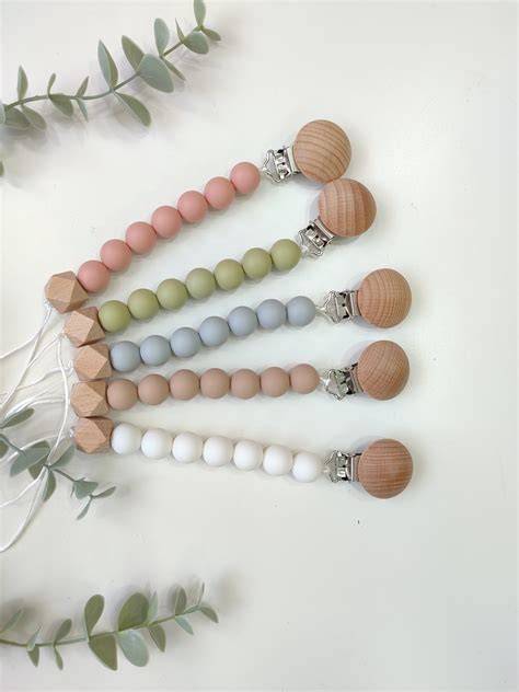 Variedad de chupeteros de silicona y madera con diferentes diseños y clips
