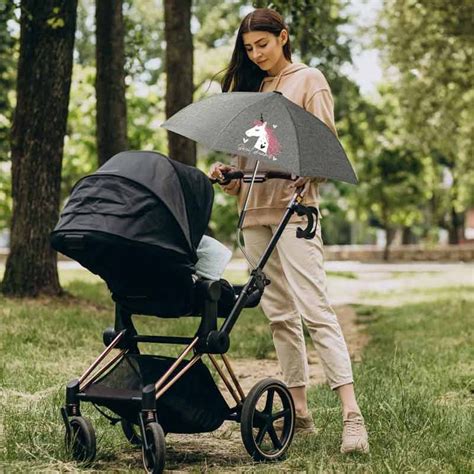 Ilustración de una sombrilla universal acoplada a una silla de paseo, con un bebé protegido del sol