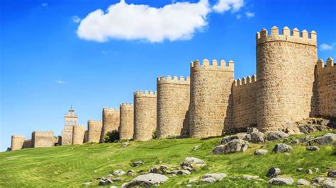 Foto panorámica de Artajona con sus murallas y un evento festivo con gigantes al fondo