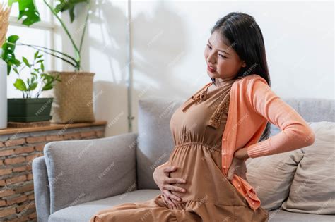 Mujer embarazada tocándose la espalda por dolor lumbar