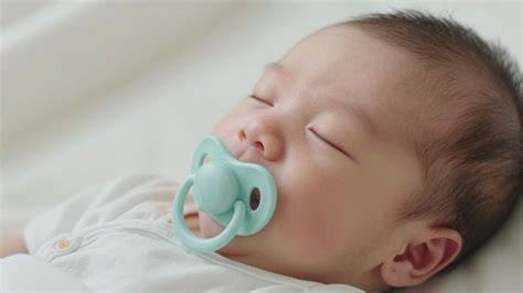 Bebé recién nacido durmiendo con un chupete