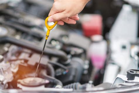 Diagrama esquemático del motor de un coche mostrando la varilla de aceite, el tapón de llenado y la correa de servicio.