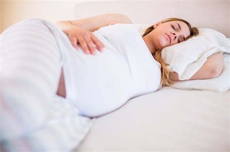 Mujer embarazada durmiendo plácidamente en una cama