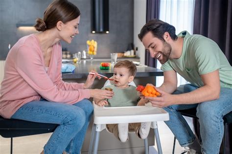 Foto de padres alimentando a un bebé con biberón, destacando la interacción afectiva