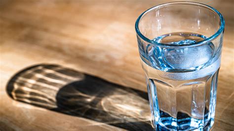 persona consumiendo dátiles y un vaso de agua, con una señal de precaución para diabéticos