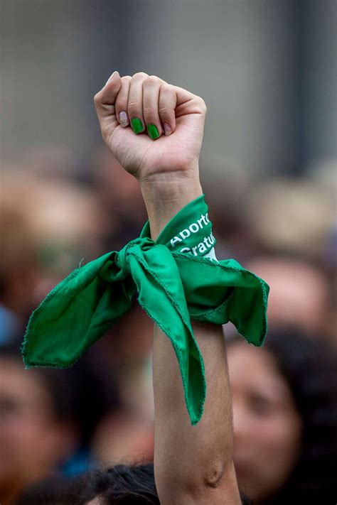 Foto de una mujer joven con pañuelo verde en una manifestación por el aborto legal