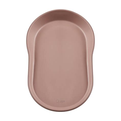 Primer plano del cambiador Quax Mamee en color coral, mostrando su diseño ergonómico y material de espuma EVA.