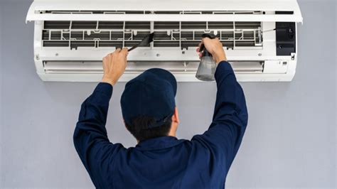 Técnico realizando mantenimiento a un serpentín de aire acondicionado