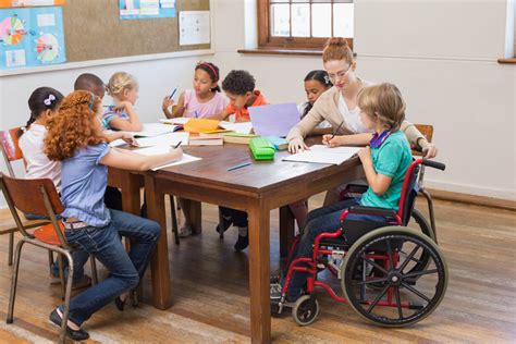 Educadora interactuando de forma inclusiva con un niño con necesidades auditivas especiales en un entorno de aprendizaje
