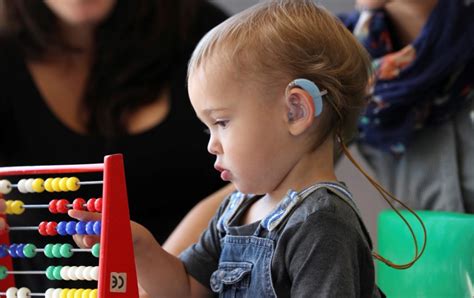 Fotografía de un niño jugando mientras se le realiza una prueba auditiva o de un niño con auriculares para PEA
