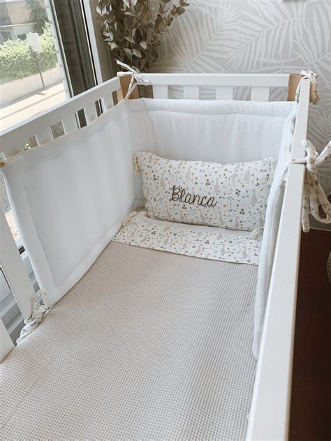 Infografía mostrando las dimensiones de una chichonera estándar para cuna de 60x120 cm.