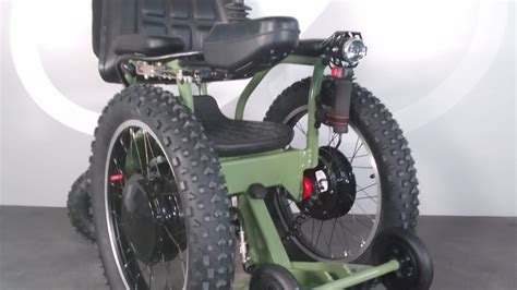 Foto de una silla gemelar todoterreno con ruedas grandes en un camino de tierra.