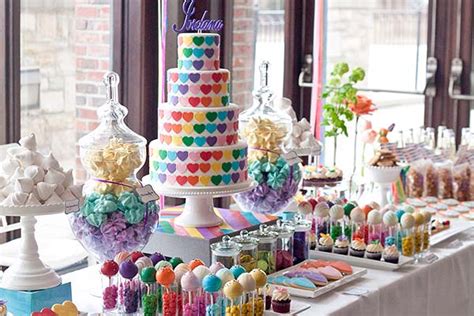 Fotografía de una mesa dulce infantil ricamente decorada con cupcakes, galletas y una tarta personalizada.